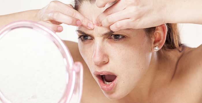 A girl removing the pimple