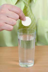 Man putting medicine tablet in a glass of water