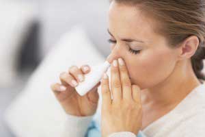 Woman using a nasal spray