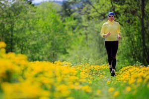 Woman running in a garden having yellow flowers