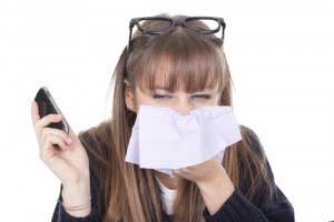 A girl covering her mouth while sneezing