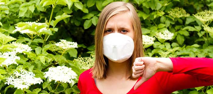 Woman being unwell from allergy to flower pollen.