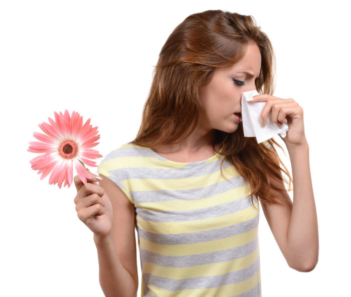 Woman covering his nose while sneezing