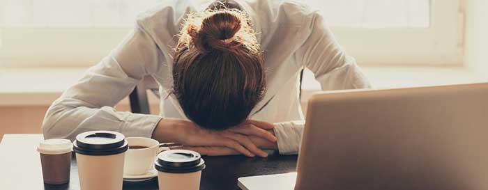 Woman sitting putting head down on the table