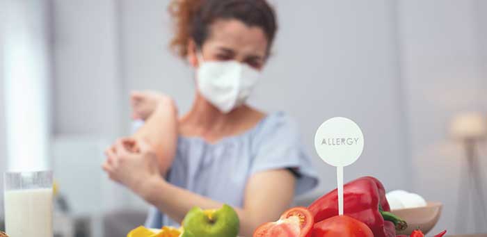 A girl covering her mouth as she has allergy